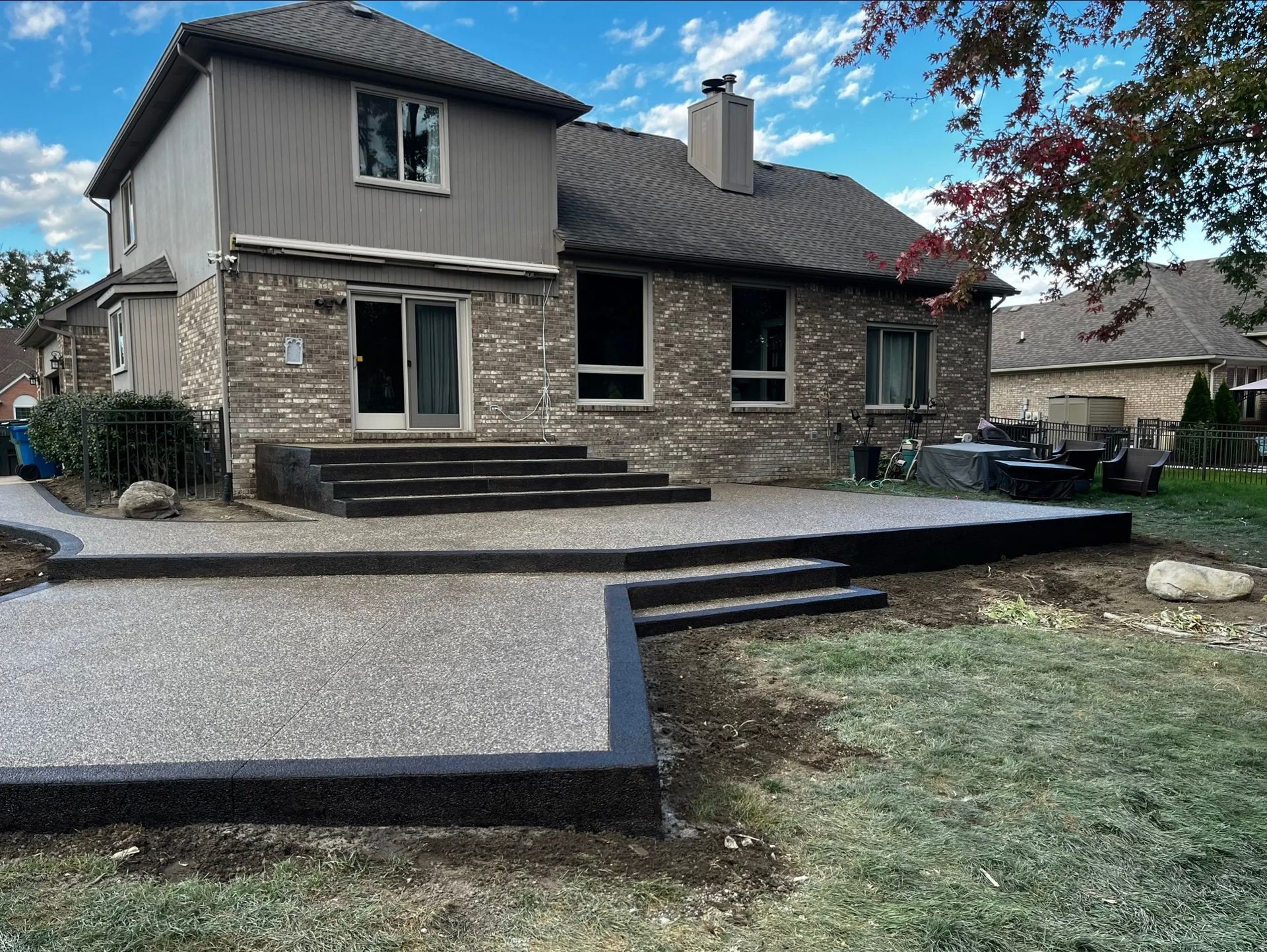 Construction of a concrete walkway around a residential rural house in manual of the pavement with a special tool.