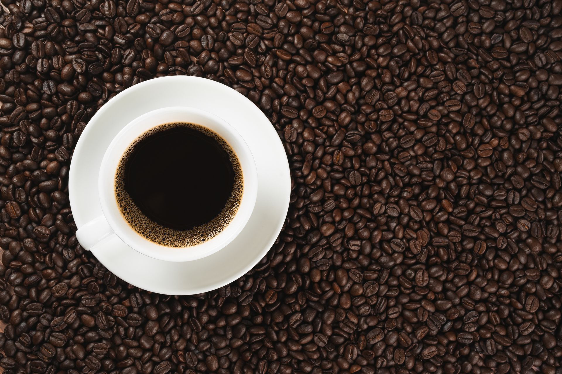 Chicken salad and two drinks on a tray. The salad has fried chicken and lettuce. One drink is yellow, the other red.