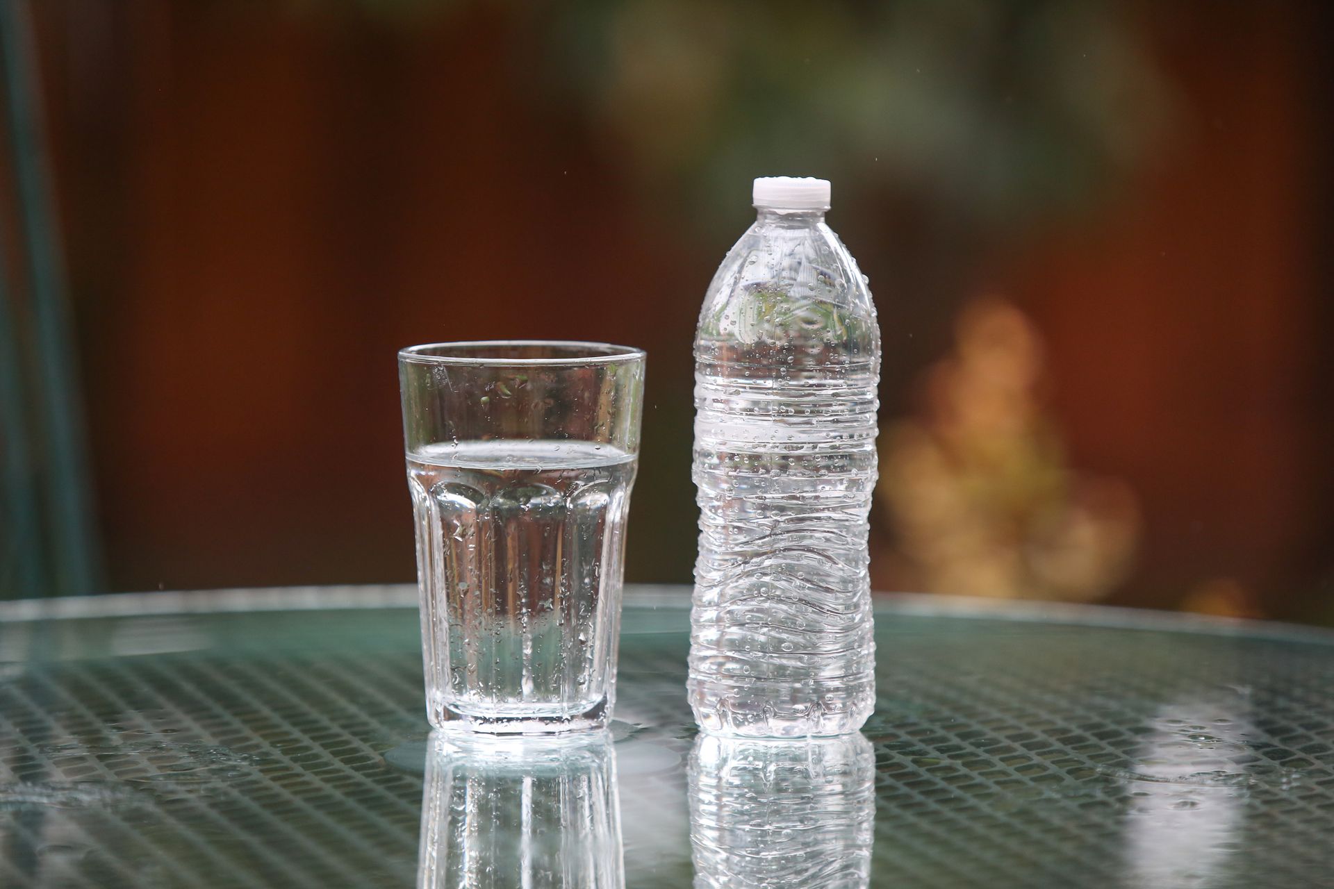 Chicken salad with two colorful drinks on a metal tray, set on a white surface.