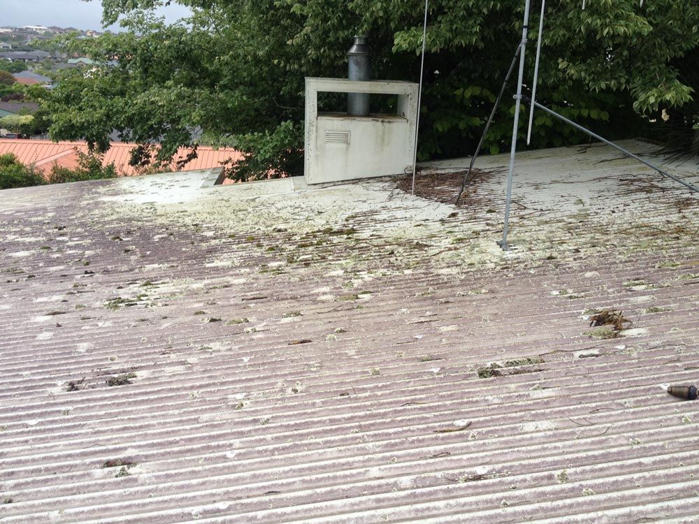 A roof with a chimney on it and a lot of leaves on it.