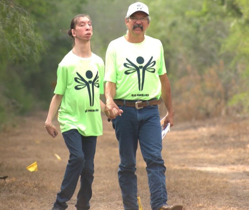A man and a woman are walking down a dirt path