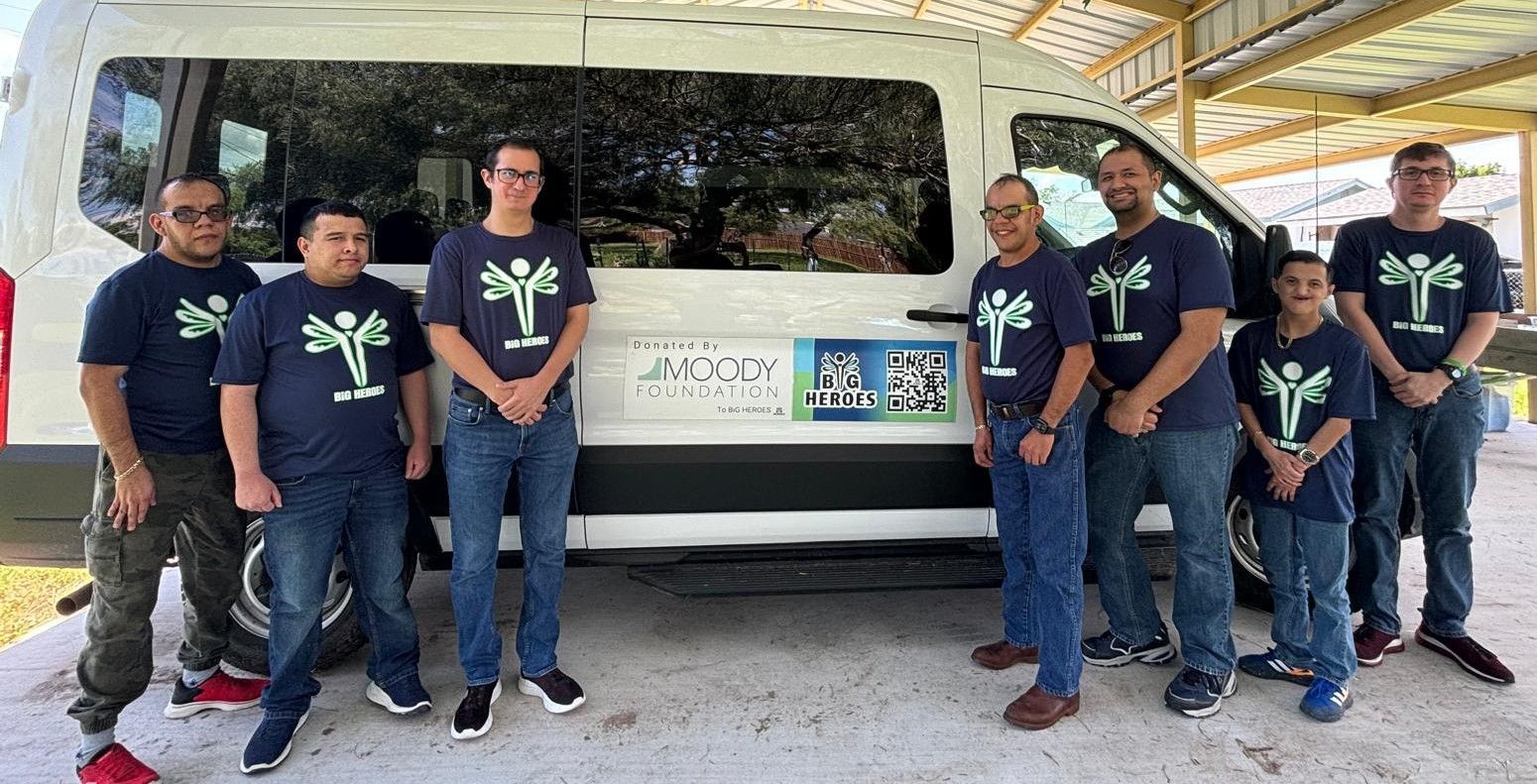 A group of people are standing in front of a white van.