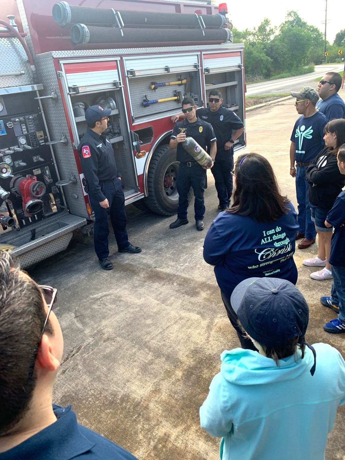 A group of people are standing in front of a fire truck.
