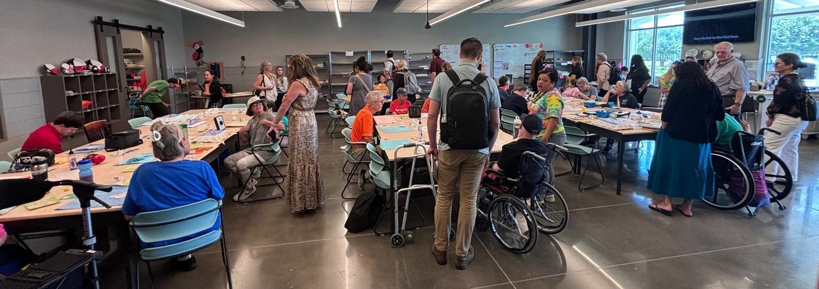 A large group of people are sitting at tables in a room.