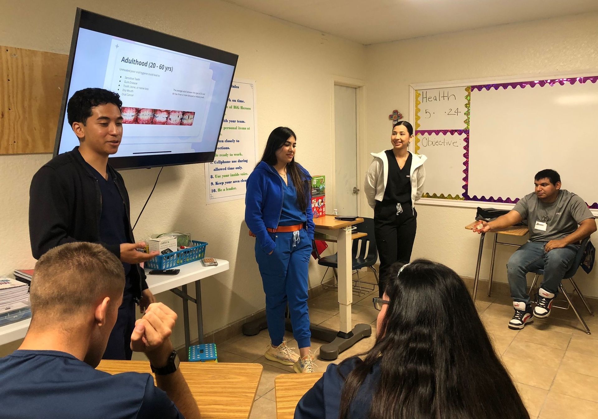 A group of people are standing in a classroom giving a presentation.