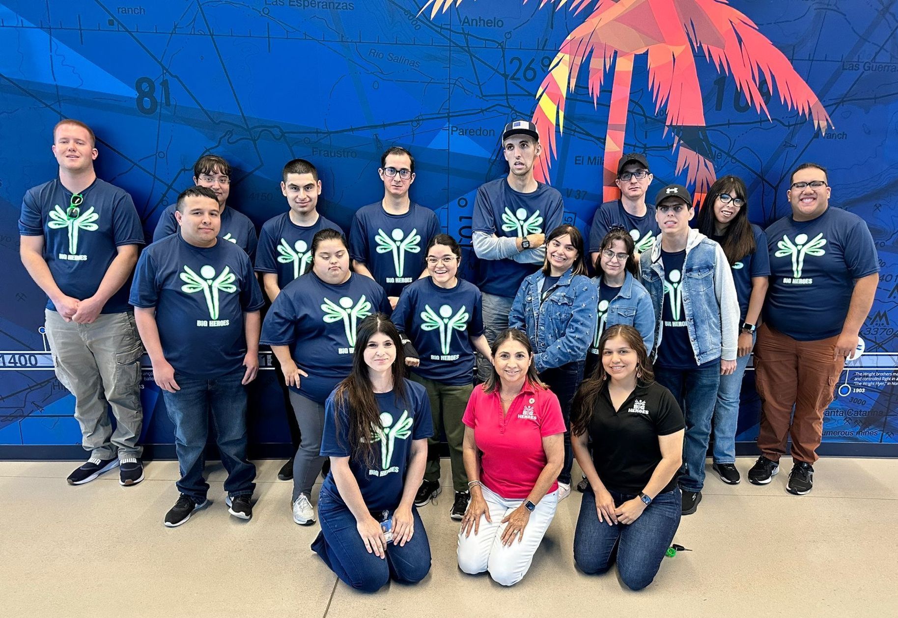 A group of people are posing for a picture in front of a map.