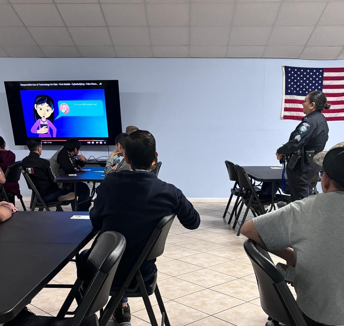 A group of people are sitting at tables watching a presentation