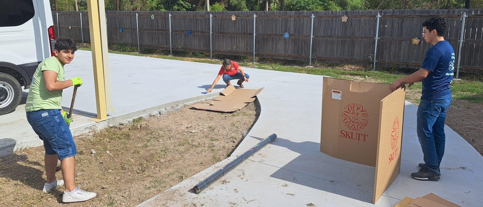 A man and a woman are standing next to a cardboard box.