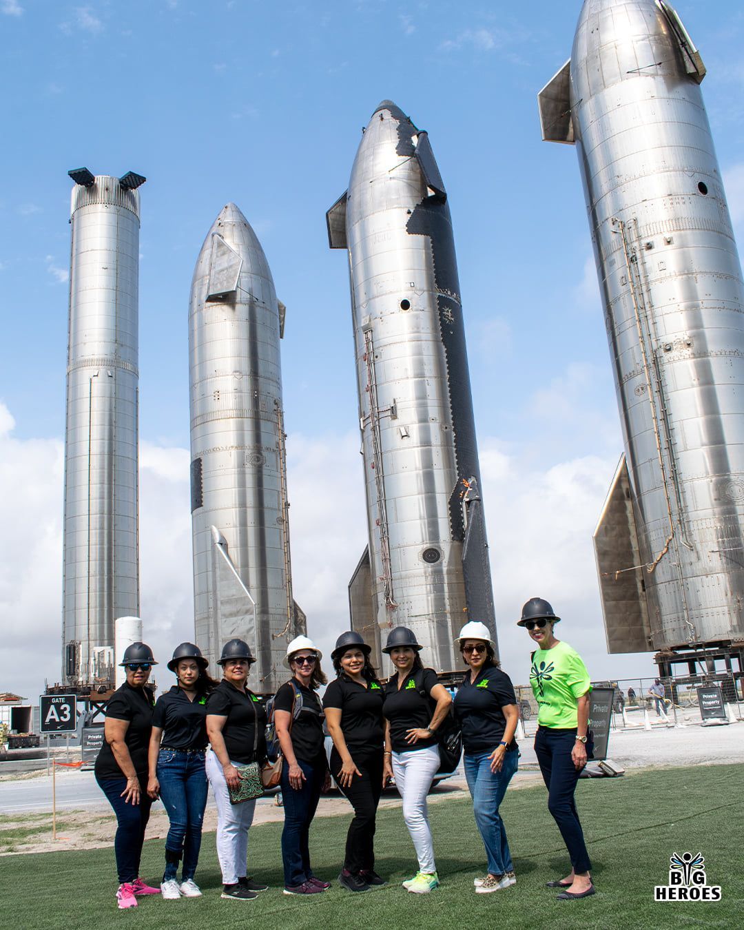A group of women are standing in front of a row of rockets.