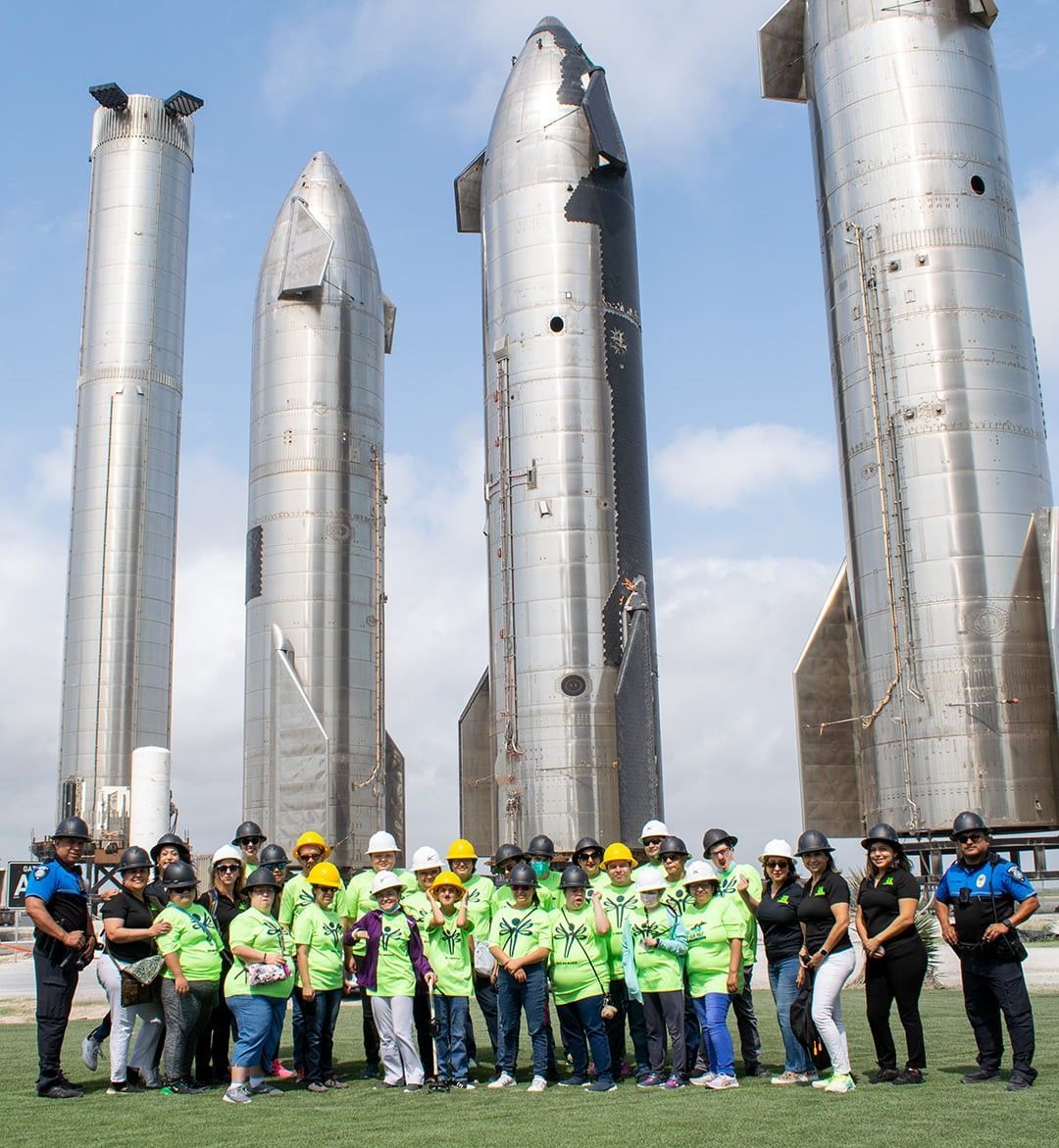 A group of people standing in front of a row of rockets