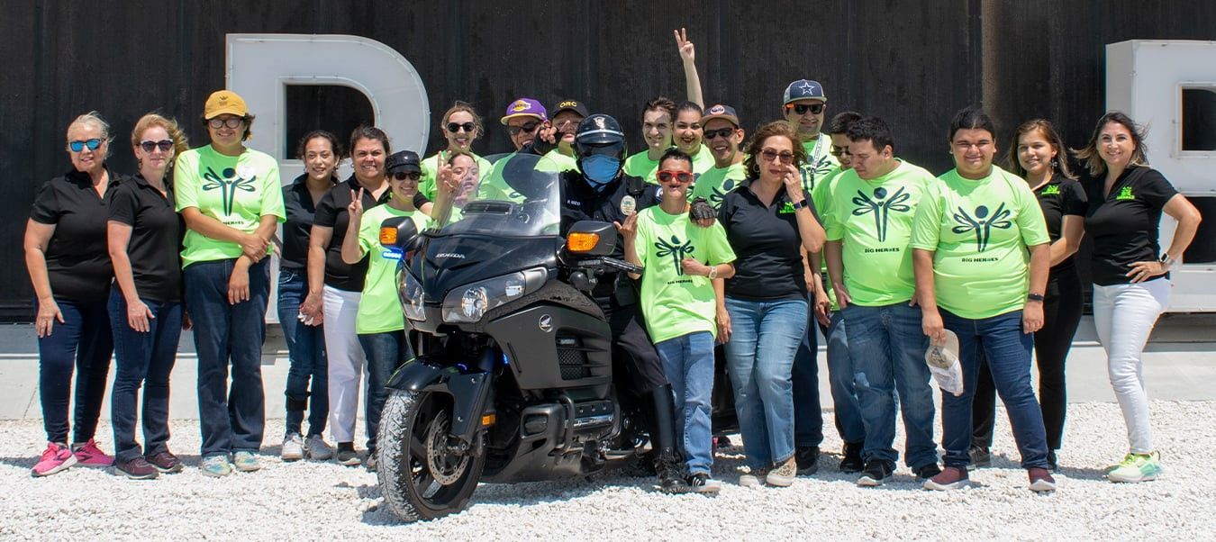 A group of people are posing for a picture in front of a motorcycle.