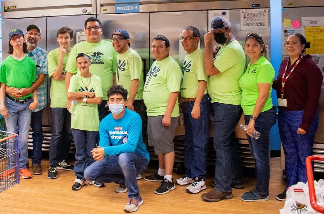 A group of people are posing for a picture in a kitchen.