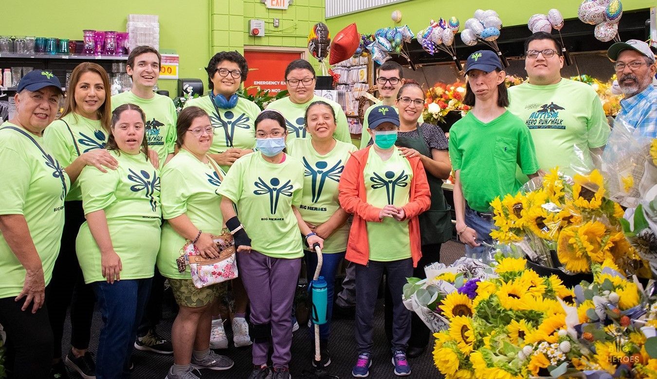 A group of people wearing green shirts are posing for a picture in a store.