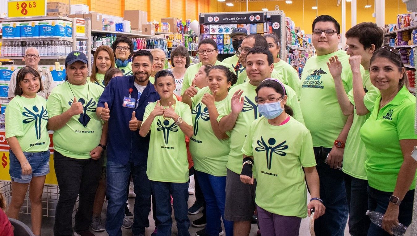 A group of people wearing green shirts are posing for a picture in a store.
