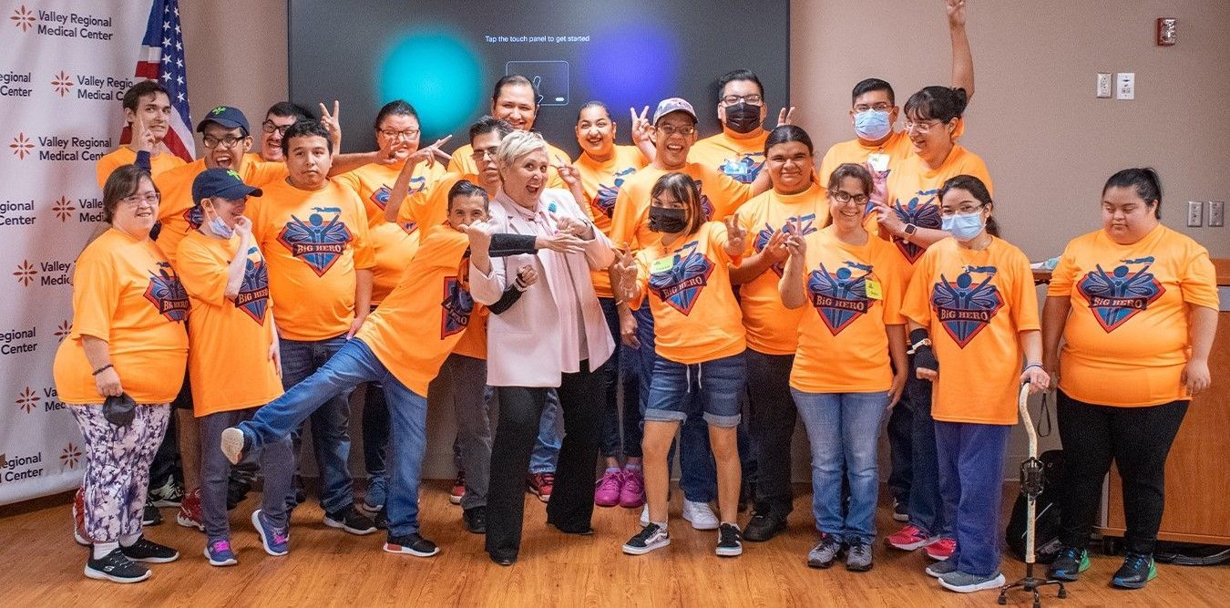 A group of people wearing orange shirts are posing for a picture.
