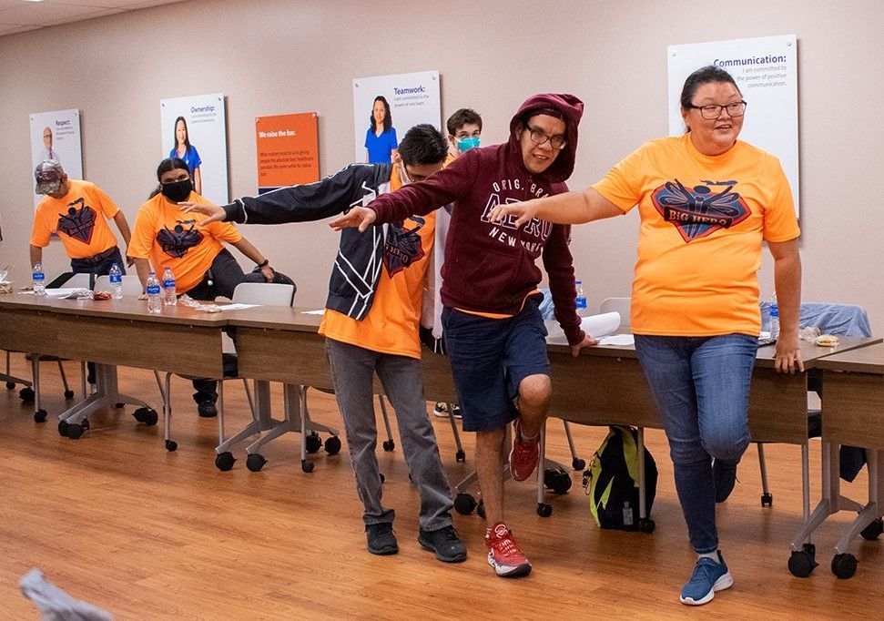 A group of people are standing around a table in a room.
