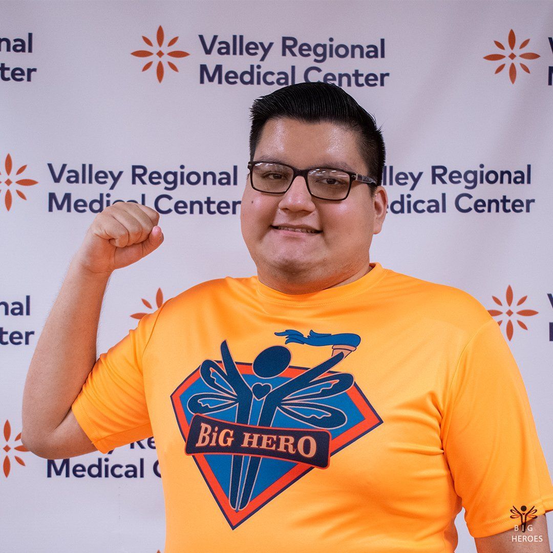 A man wearing an orange shirt that says big hero