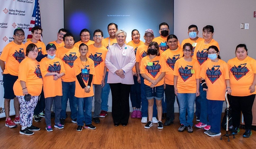 A group of people wearing orange shirts are posing for a picture.