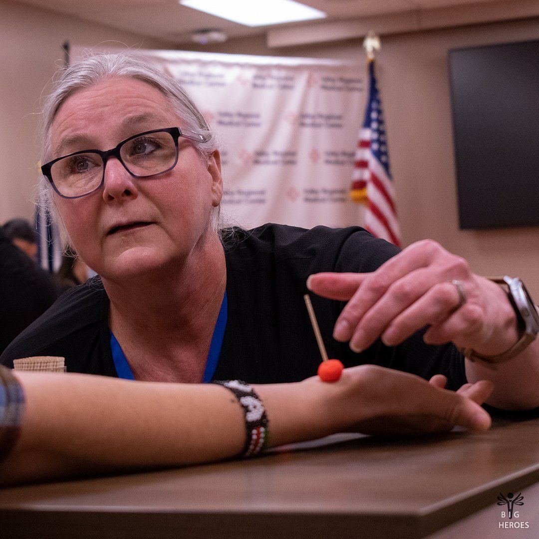 A woman with glasses is holding a red object in her hand