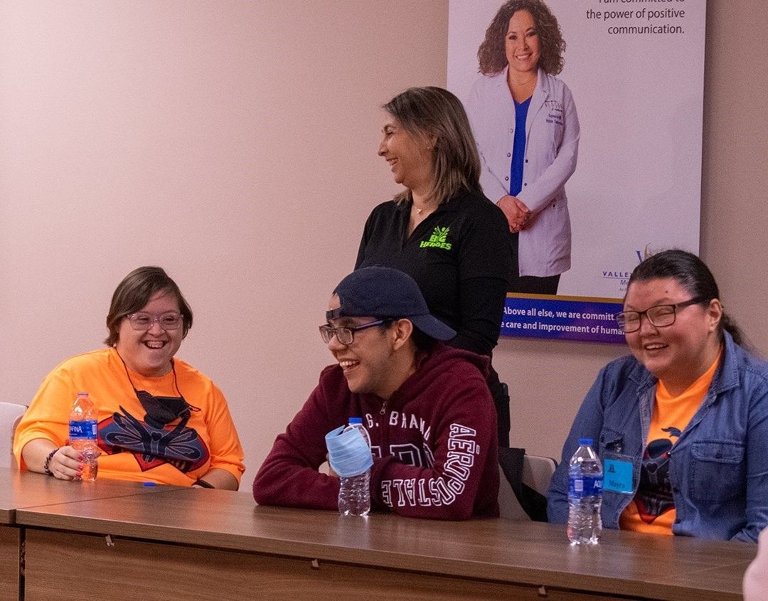 A group of people are sitting at a table with water bottles.