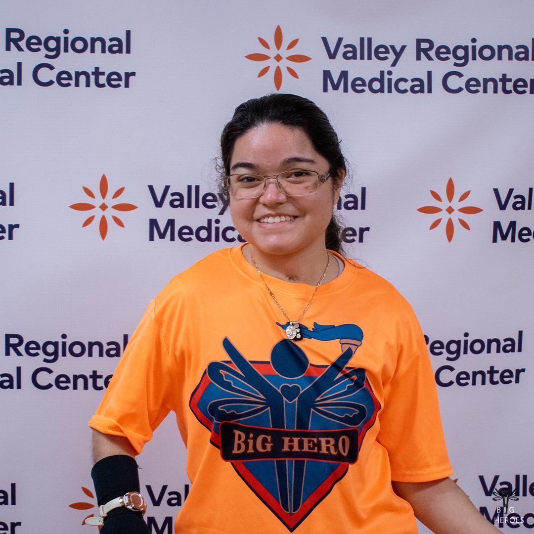 A woman wearing an orange shirt that says big hero