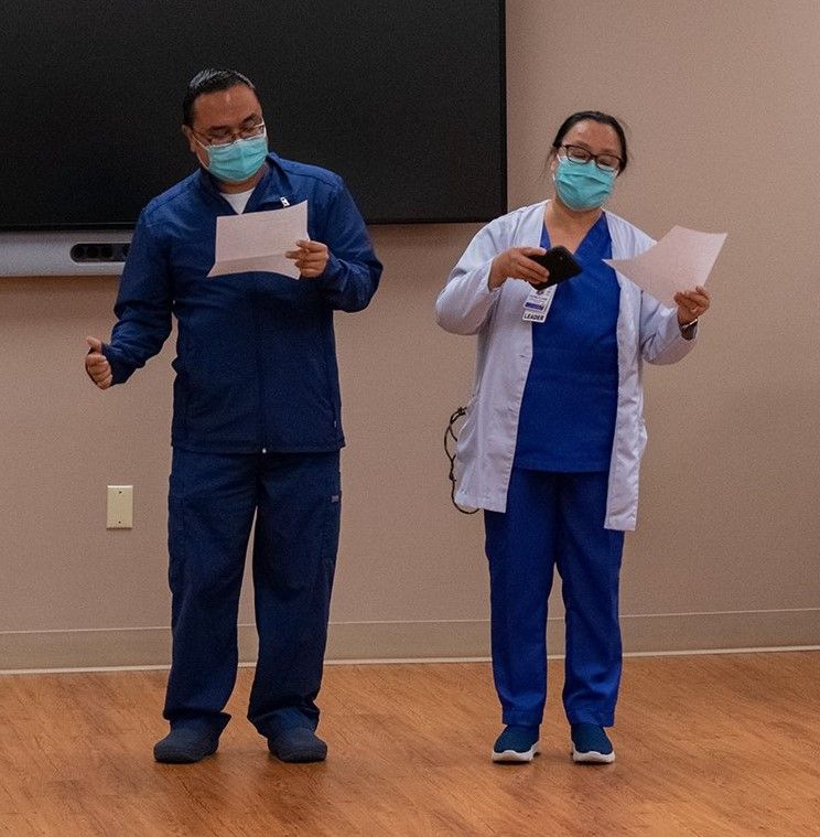 A man and a woman wearing masks are standing next to each other