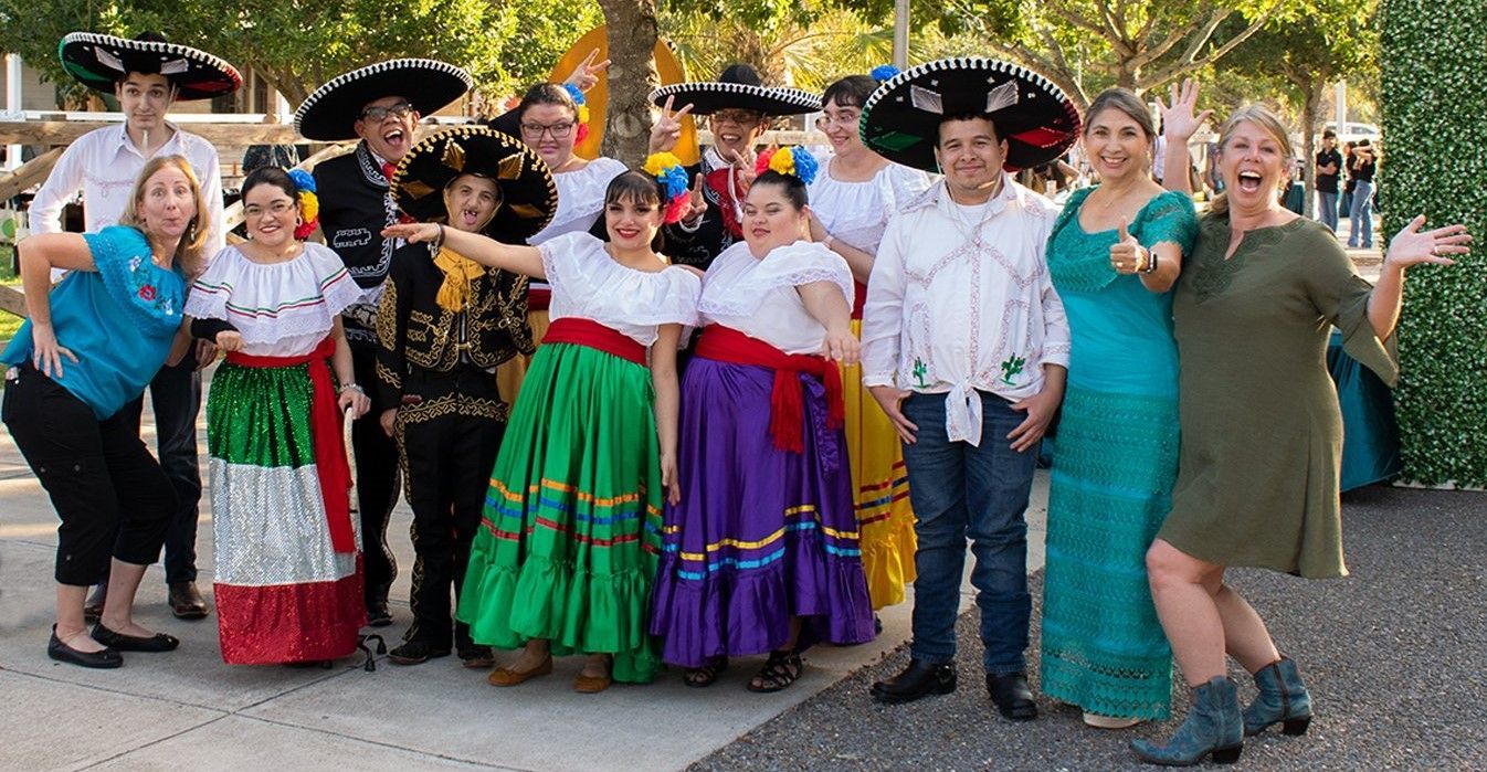 A group of people in traditional mexican costumes are posing for a picture.