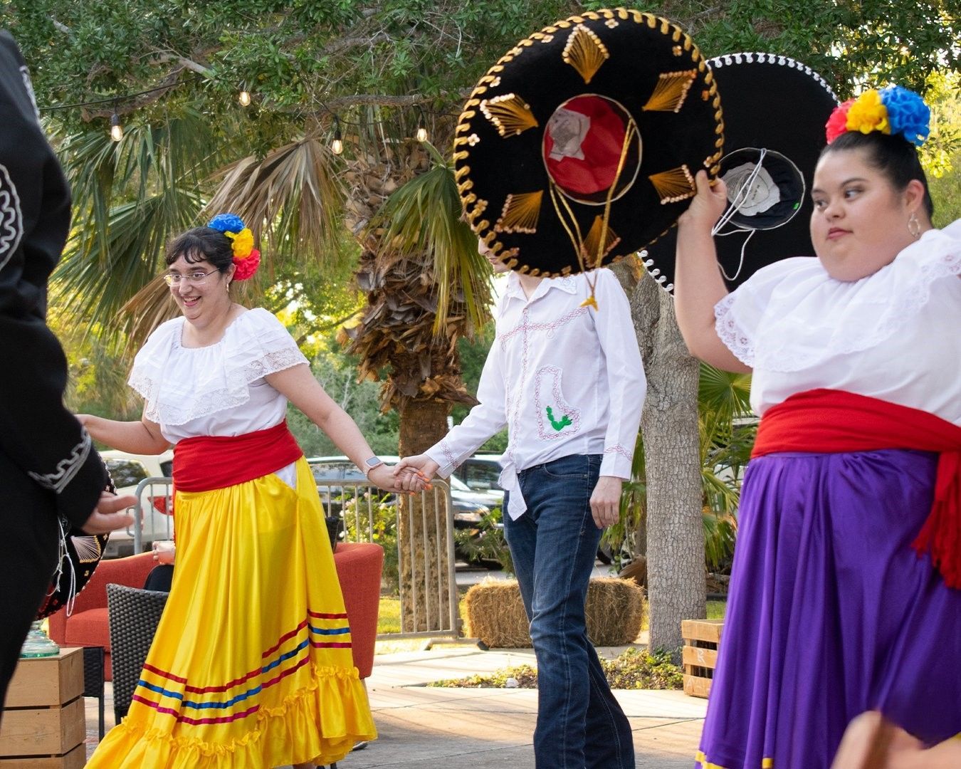 A group of women in traditional mexican costumes are dancing