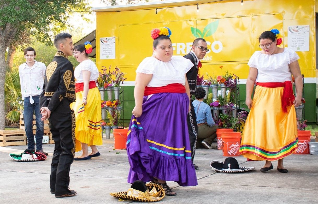 A group of people are dancing in front of a truck that says fresco