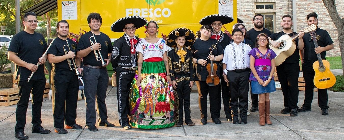 A group of people are standing in front of a yellow truck.