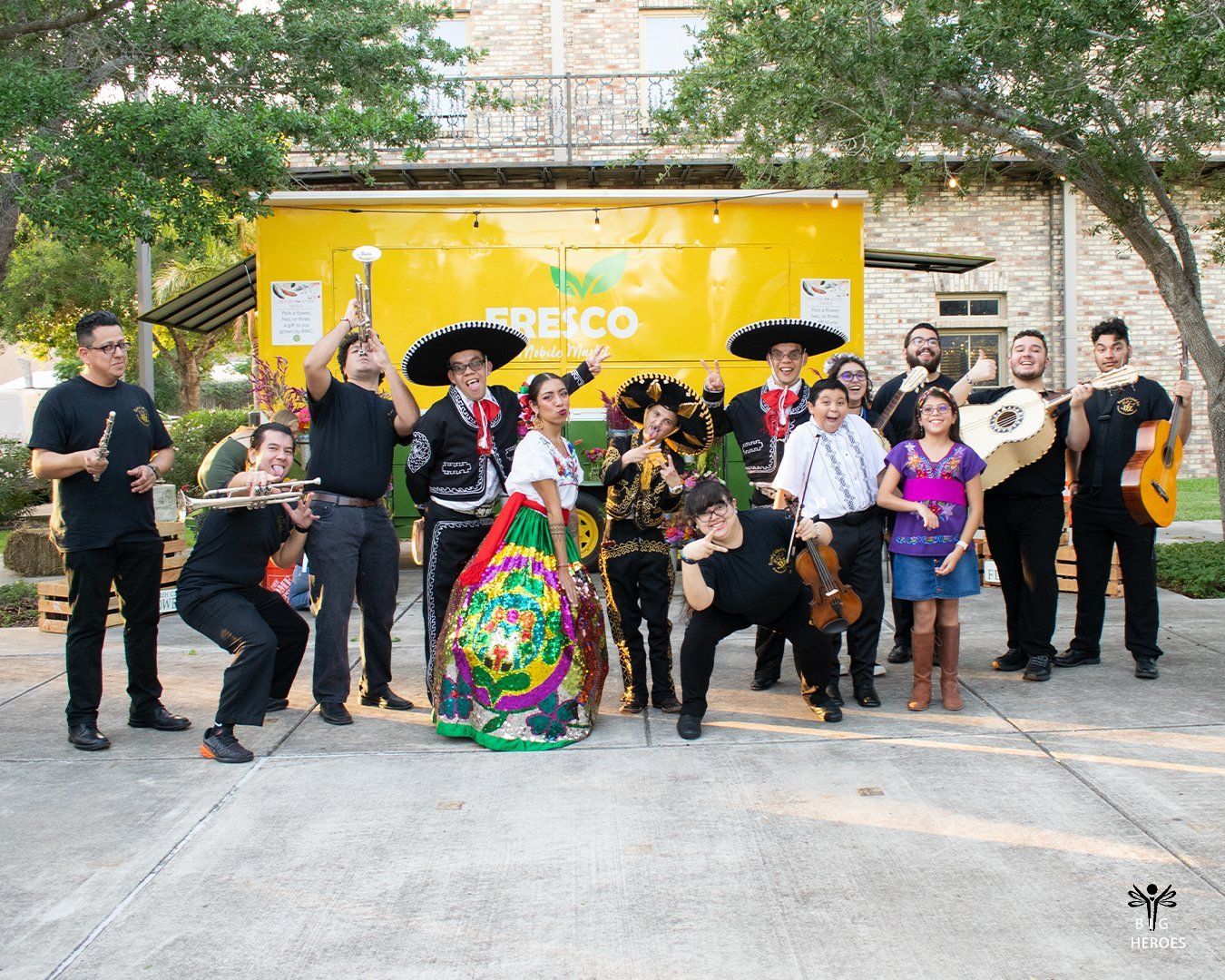A group of people are posing for a picture in front of a yellow truck.