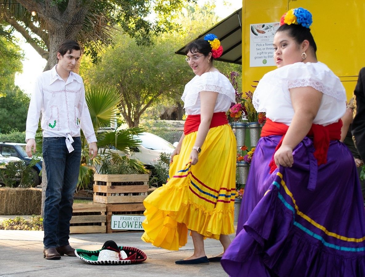 A man standing next to three women in traditional mexican clothing