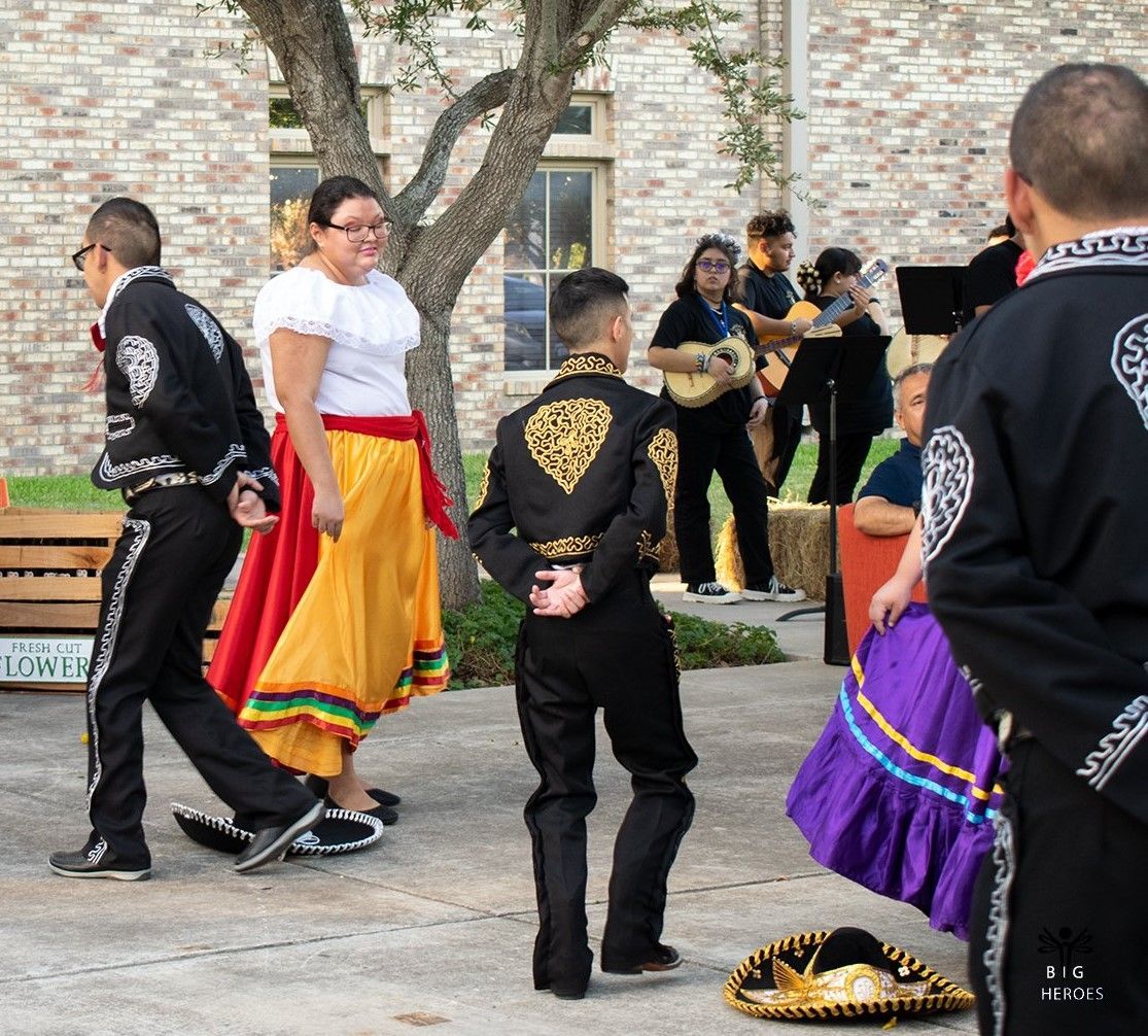 A group of people are dancing in front of a brick building
