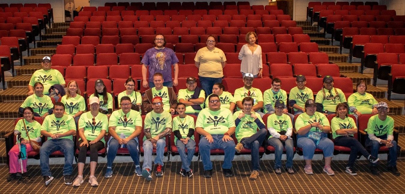 A group of people are posing for a picture in an auditorium.