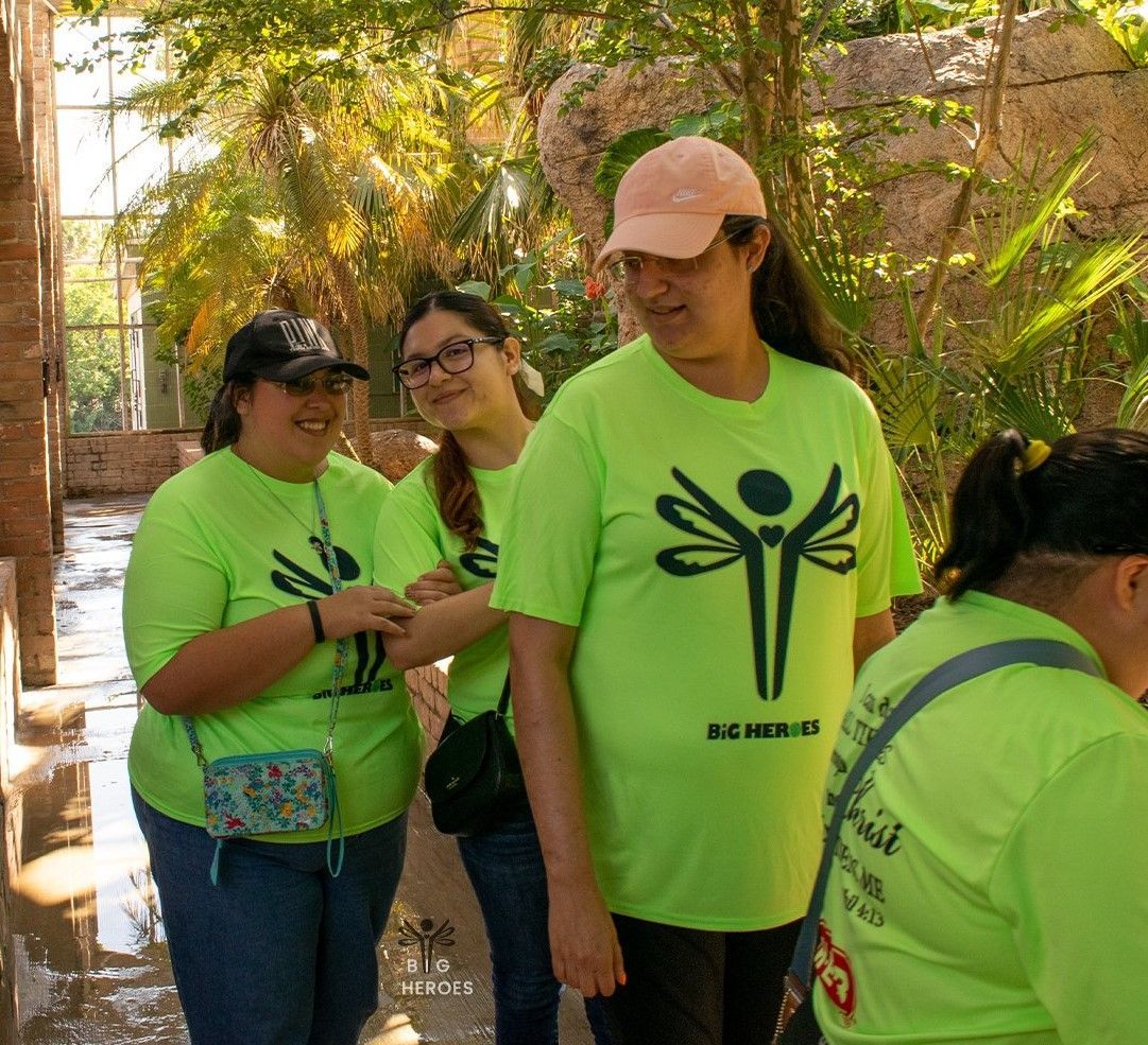 A group of people wearing green shirts with a dragonfly on them