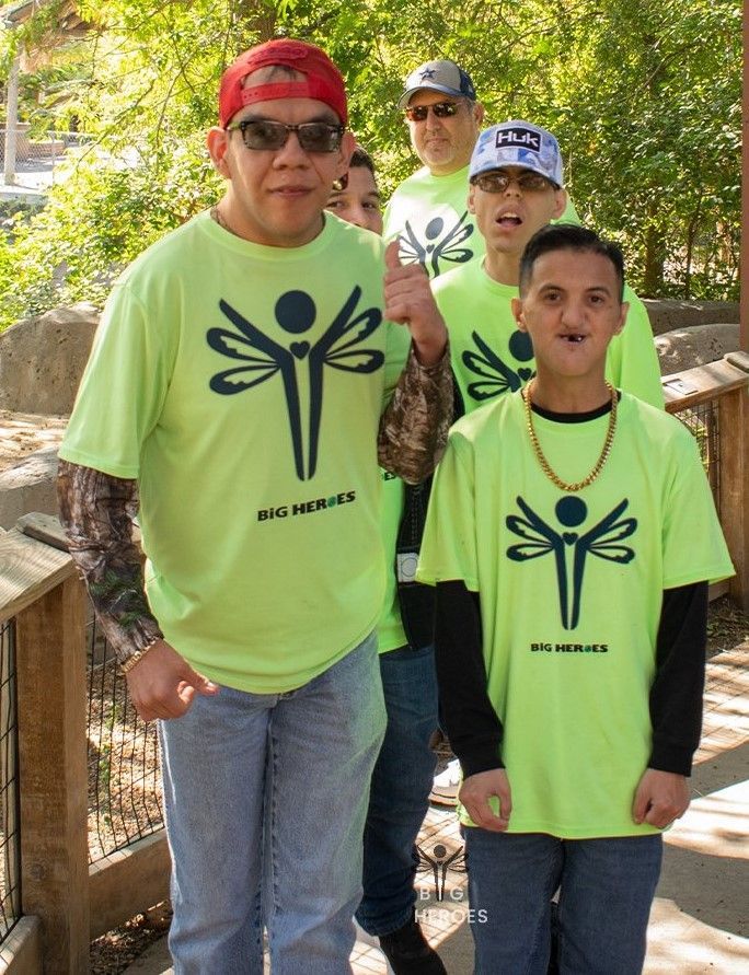 A group of people wearing neon green shirts with dragonflies on them