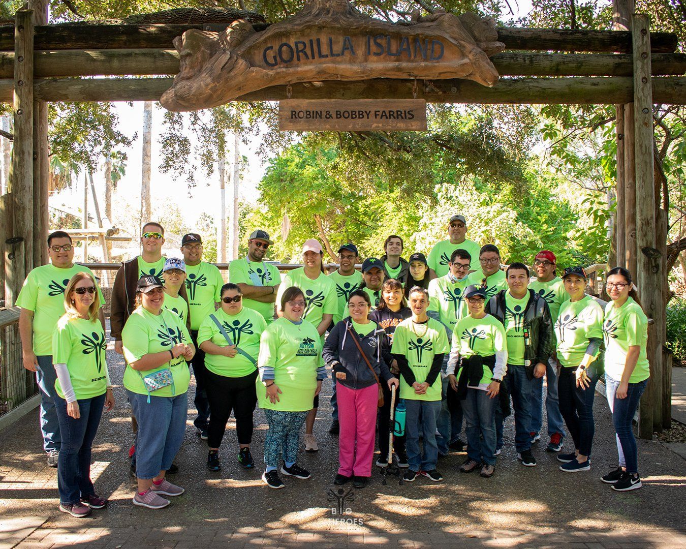 A group of people are posing for a picture in front of a gorilla island sign.