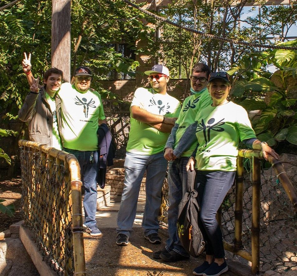 A group of people wearing green shirts are posing for a picture