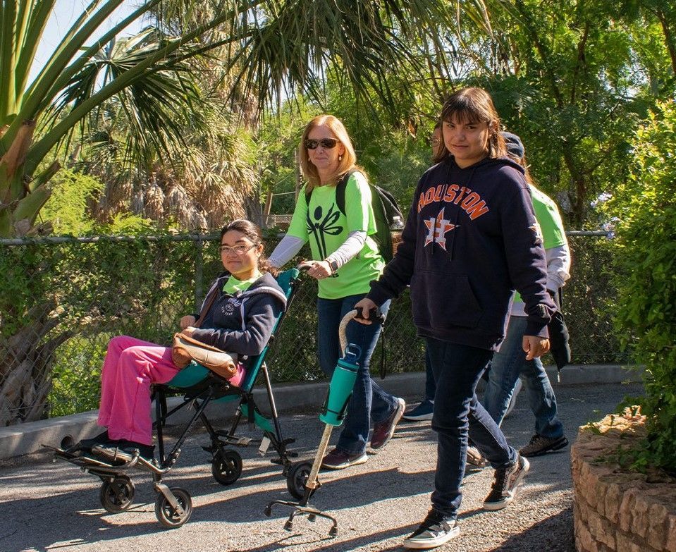 A girl wearing a sweatshirt that says houston is pushing a stroller