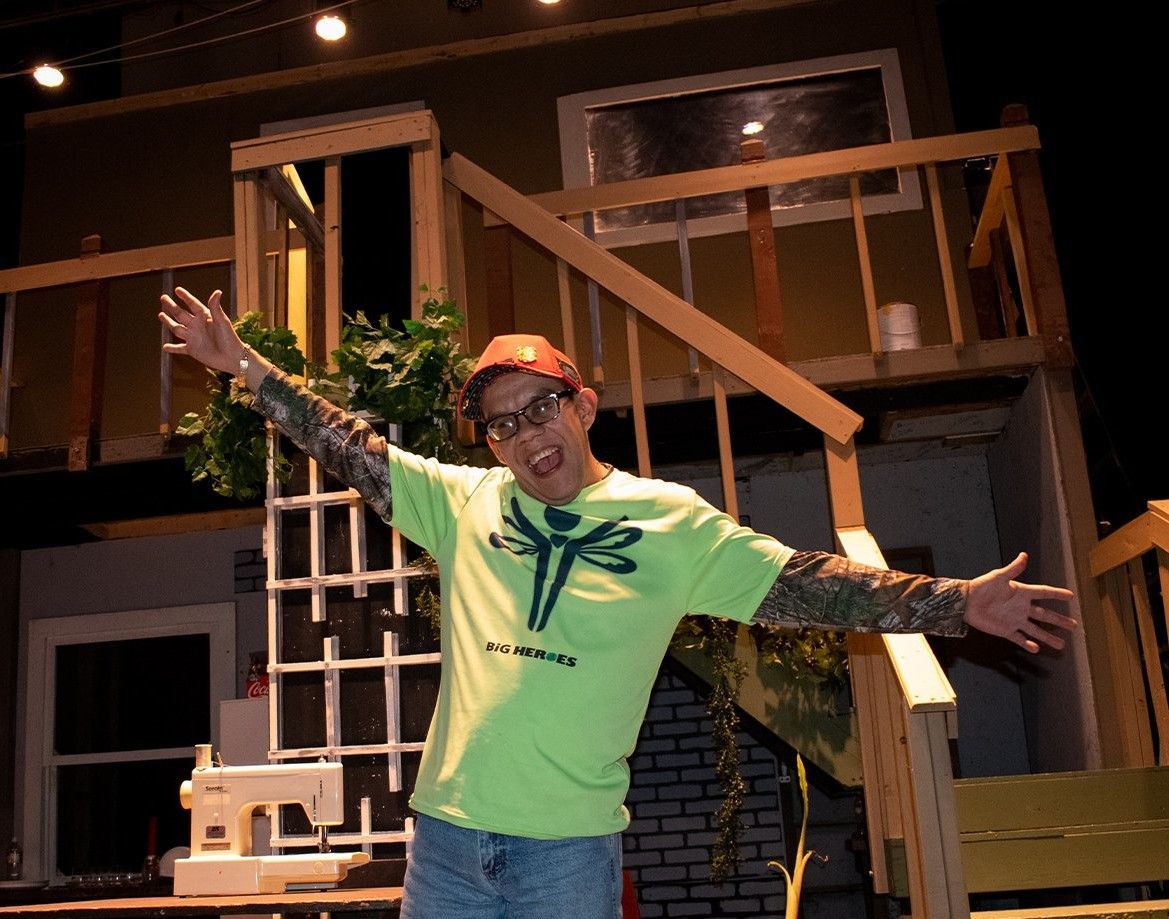 A man wearing a green shirt with a dragonfly on it