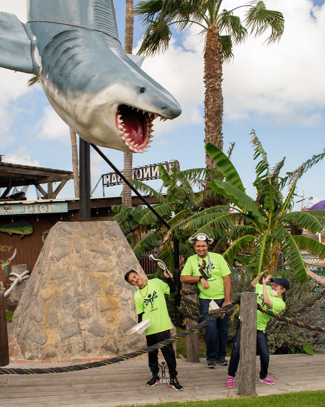 A group of people standing in front of a statue of a shark