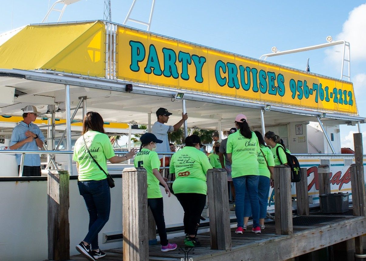 A group of people standing in front of a yellow sign that says party cruises