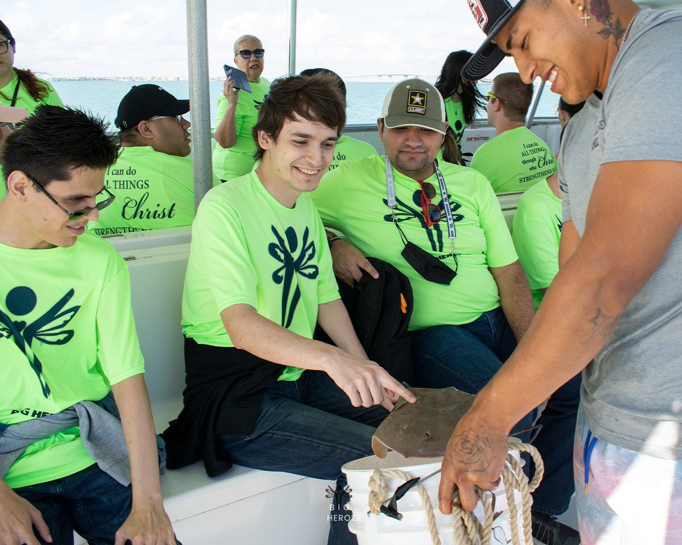 A group of people on a boat wearing green shirts that say christ