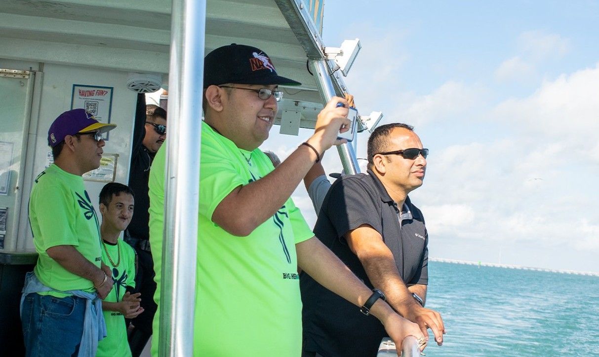 A group of men are standing on a boat in the ocean.
