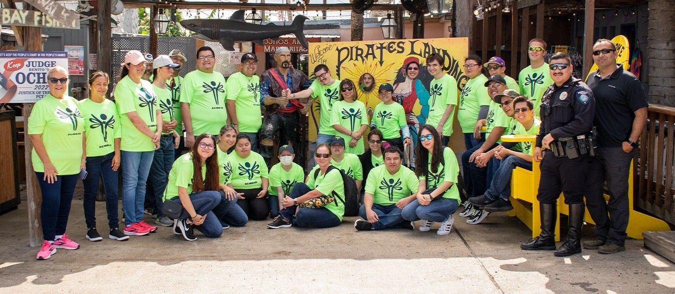 A group of people wearing neon green shirts are posing for a picture.