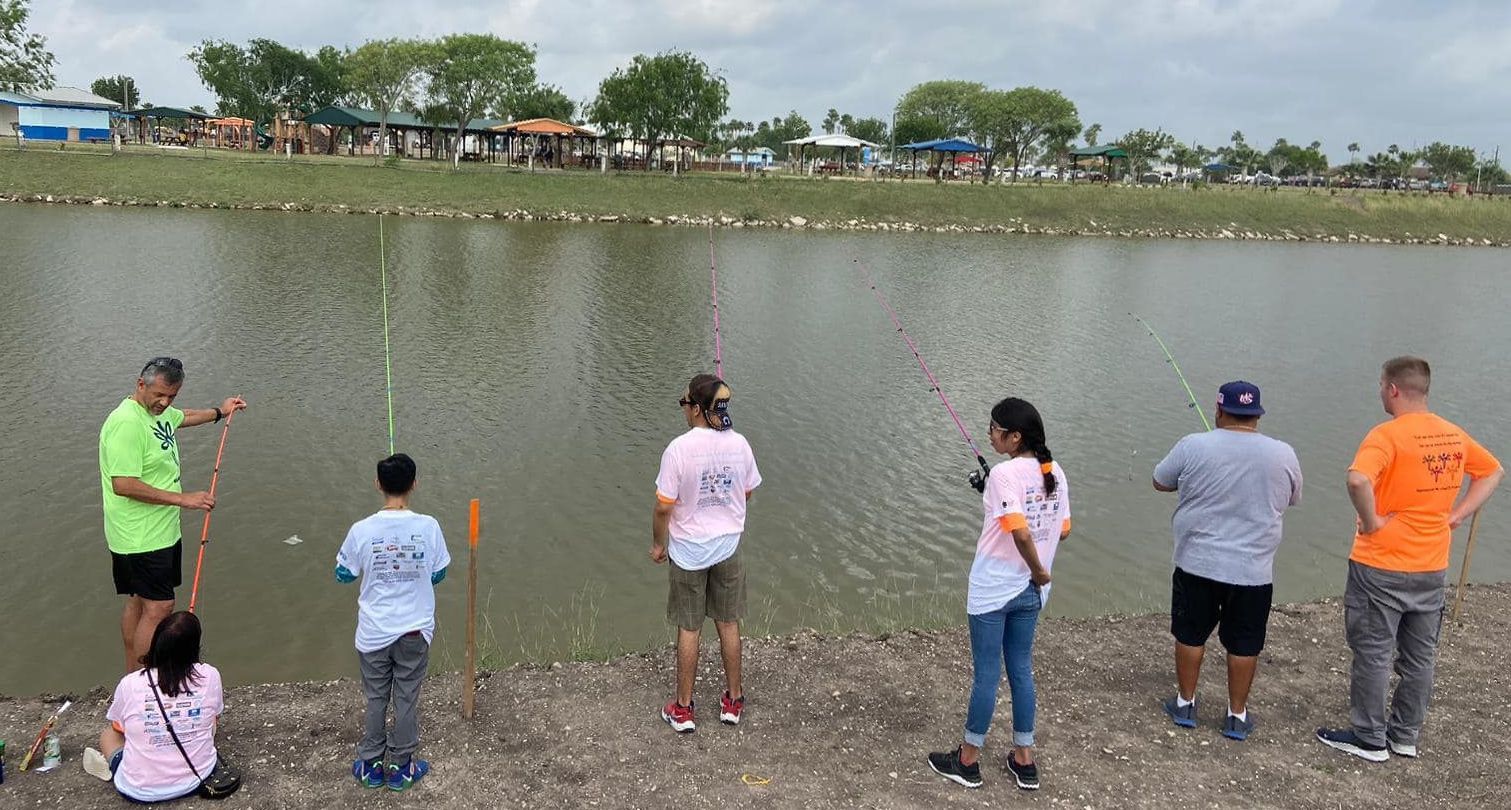 A group of people are fishing in a lake.