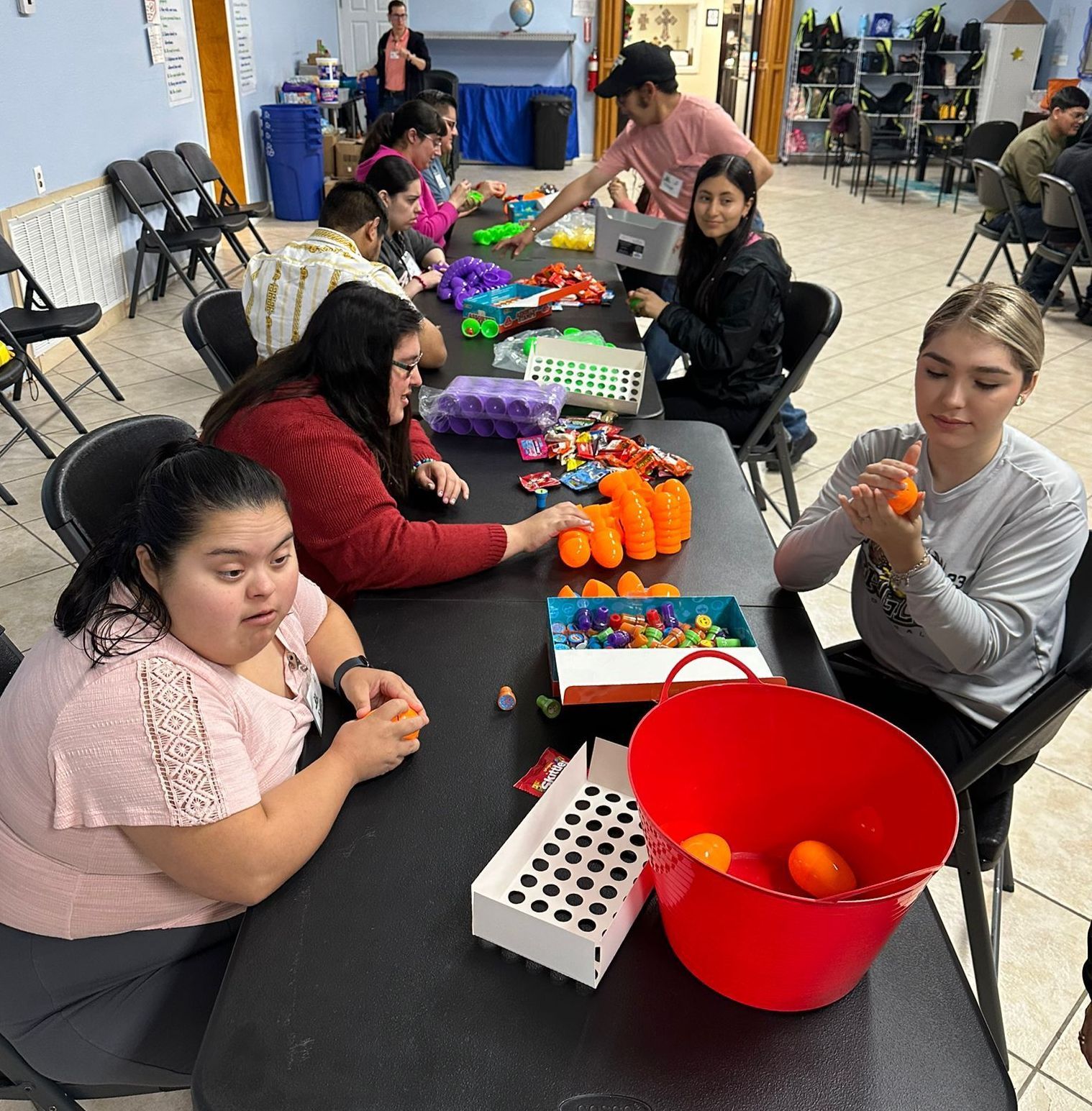 A group of people are sitting around a table with toys on it