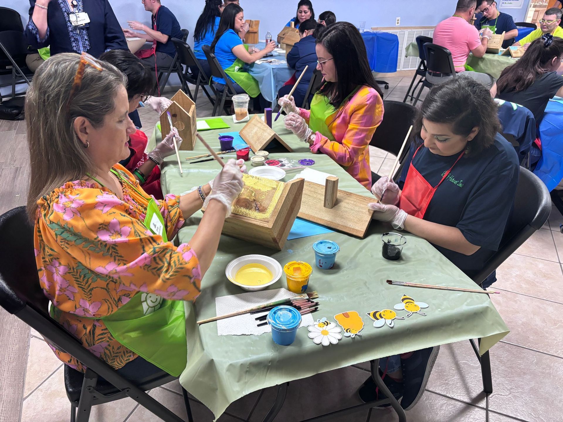 A group of people are sitting around a table painting.