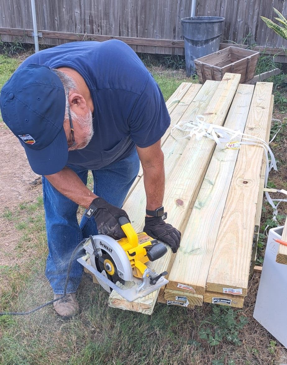 A man is using a circular saw to cut a piece of wood.