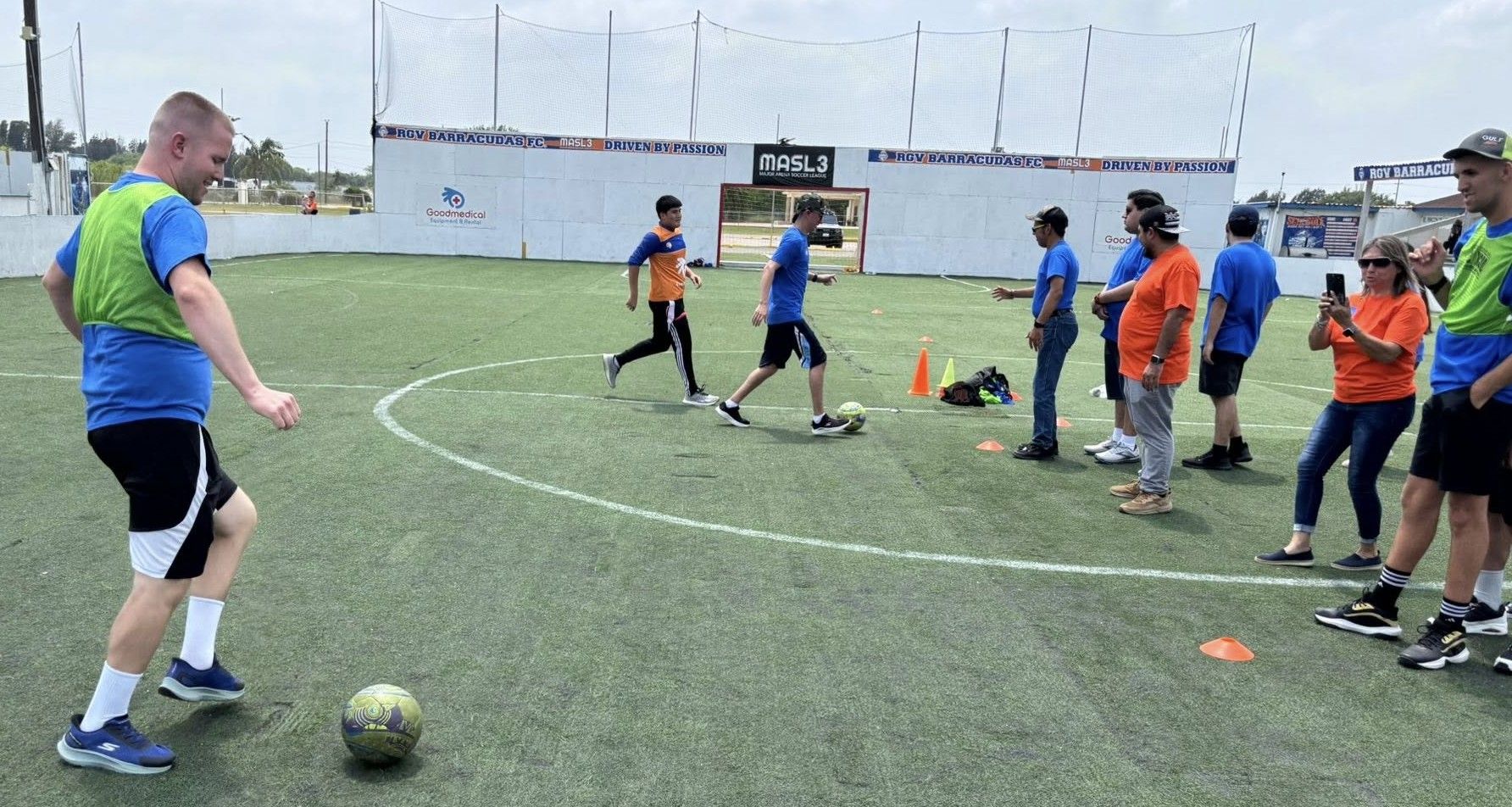 A group of people are playing soccer on a field.